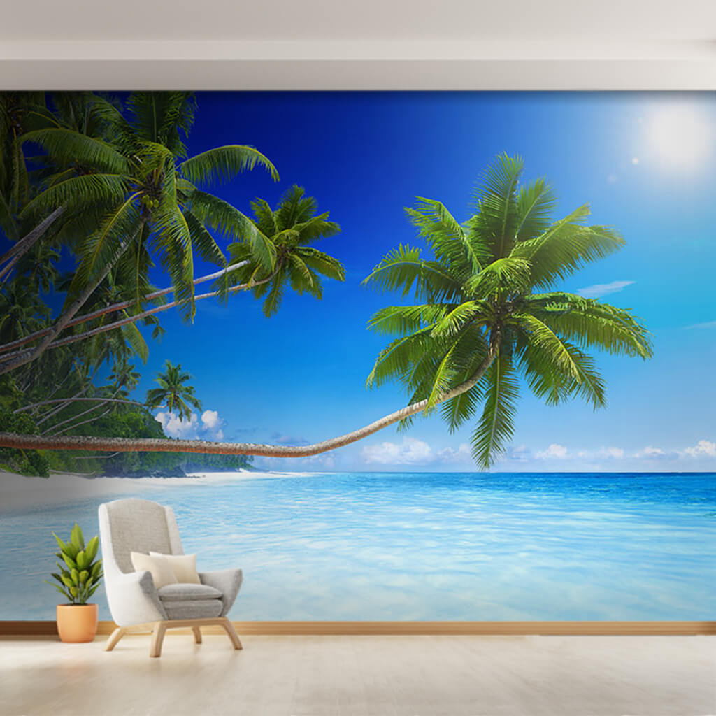 Palm trees extended towards the turquoise blue sea wall mural
